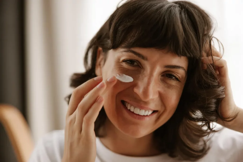 Uma mulher a aplicar um cremes para manchas no rosto - despigmentante