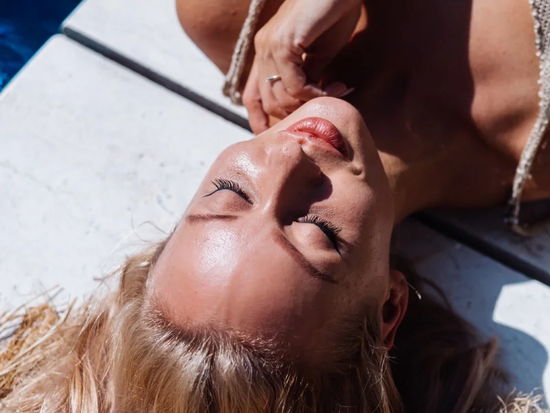 foto próxima de o rosto de uma mulher deitada no chão exposta ao sol