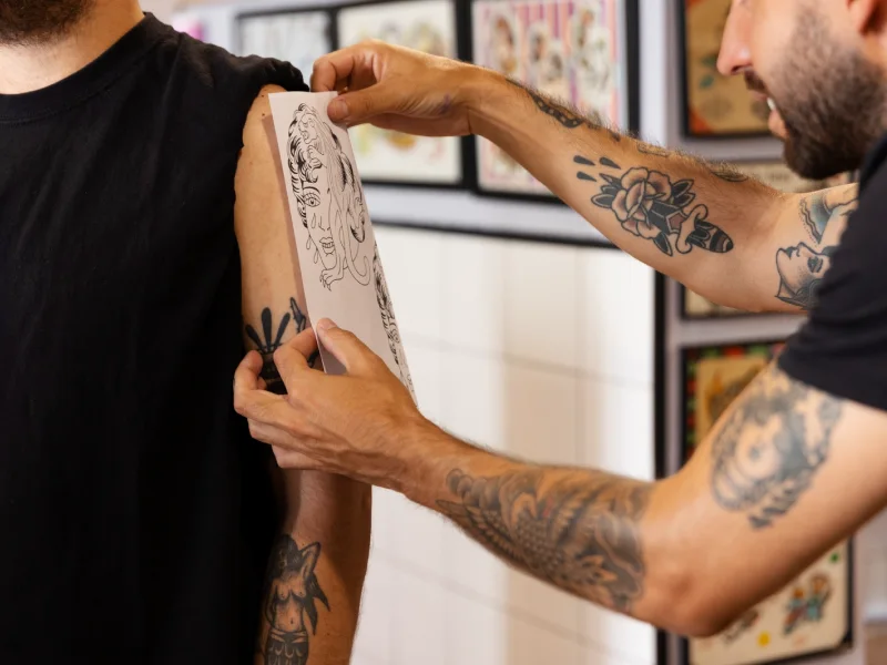 um homem tatuador a preparar a para fazer uma tatuagem